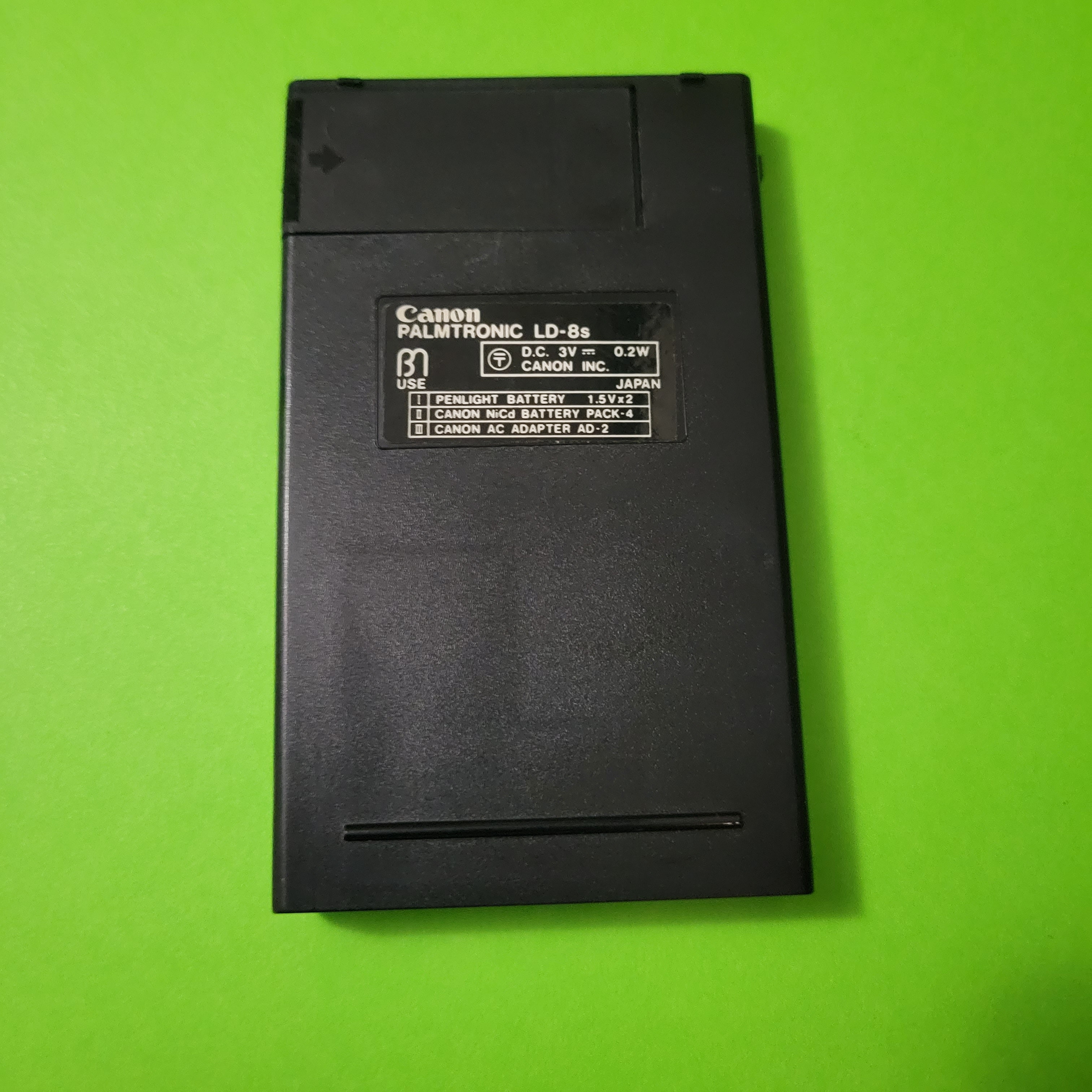 An image of the back of a Canon Palmtronic 8s four function plus calculator
